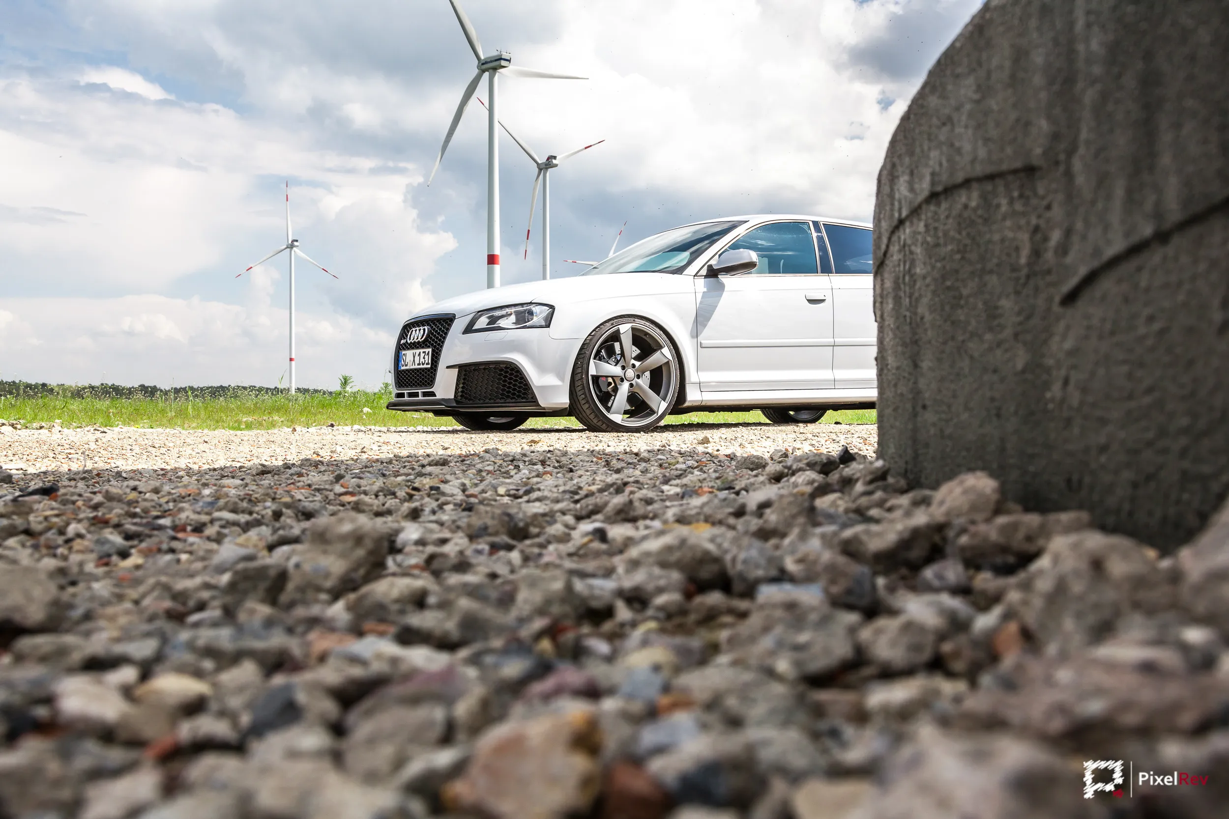 Weißer Audi RS3 Sportback im Windpark, Schotter im Vordergrund