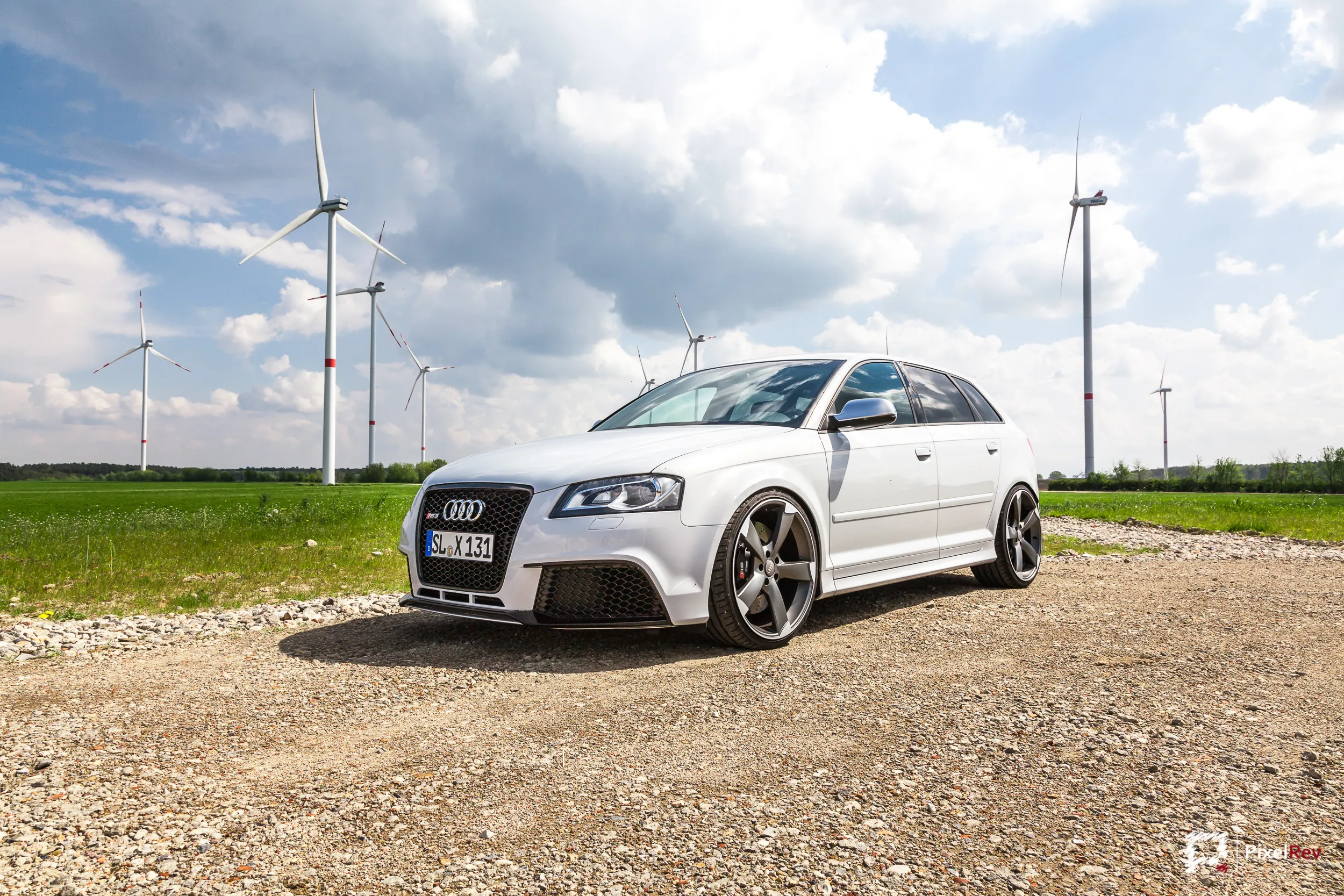 Weißer Audi RS3 Sportback vor Windrädern in Brandenburg