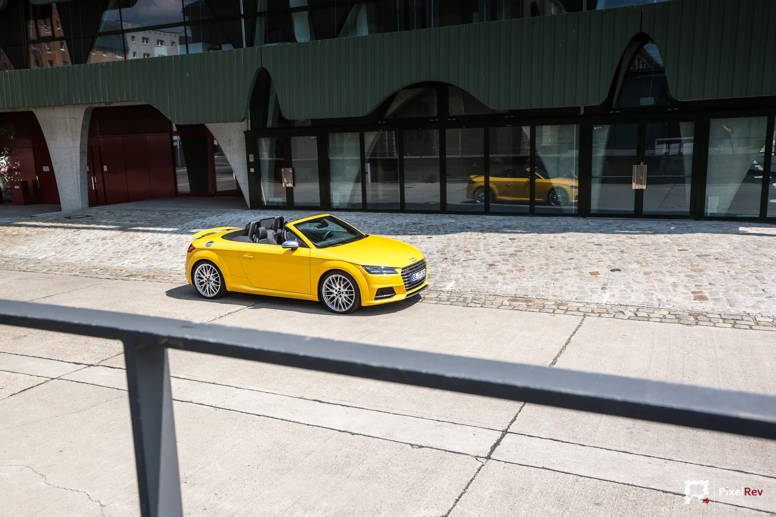 Gelber Audi TTS Roadster vor einem Arkadengebäude in Berlin