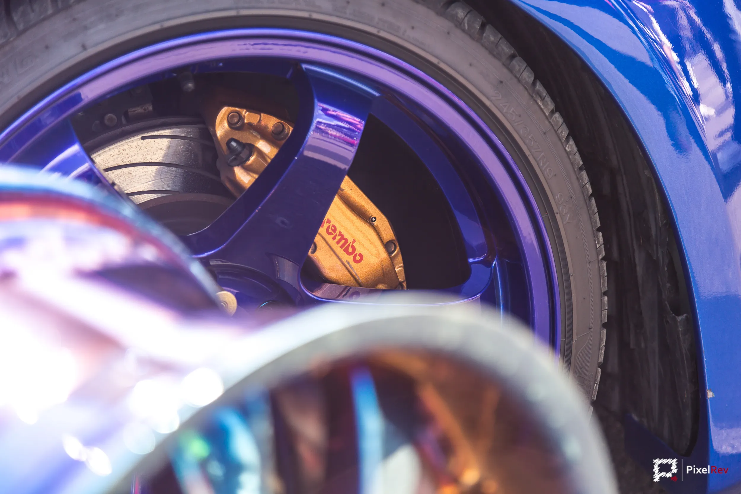 Goldener Brembo-Bremssattel hinter einer Felge, Detailaufnahme
