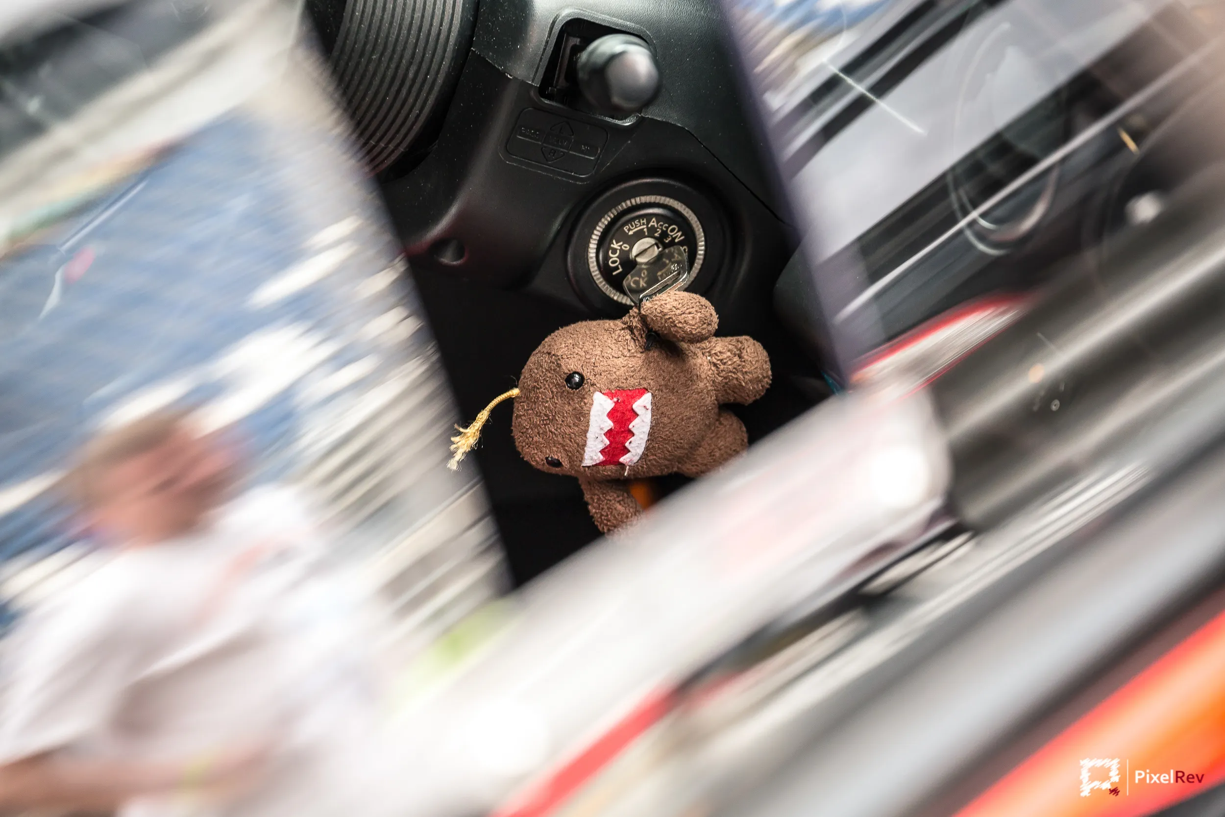 Domo-Plüschfigur im Innenraum eines Fahrzeugs, Umgebung in Bewegungsunschärfe