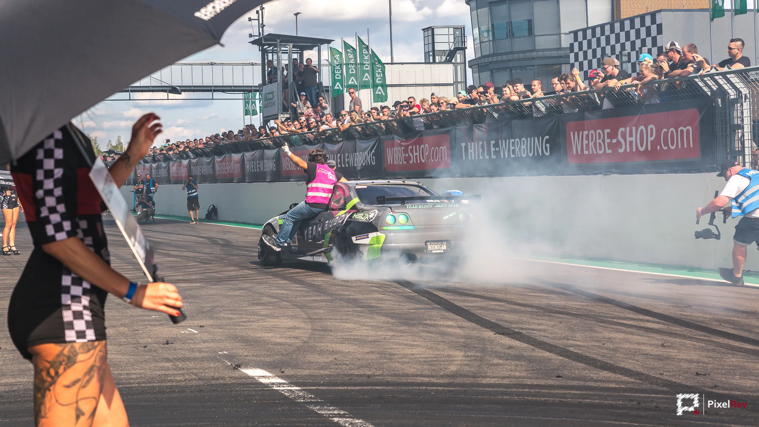 Driftfahrzeug vor voll besetzter Zuschauertribüne