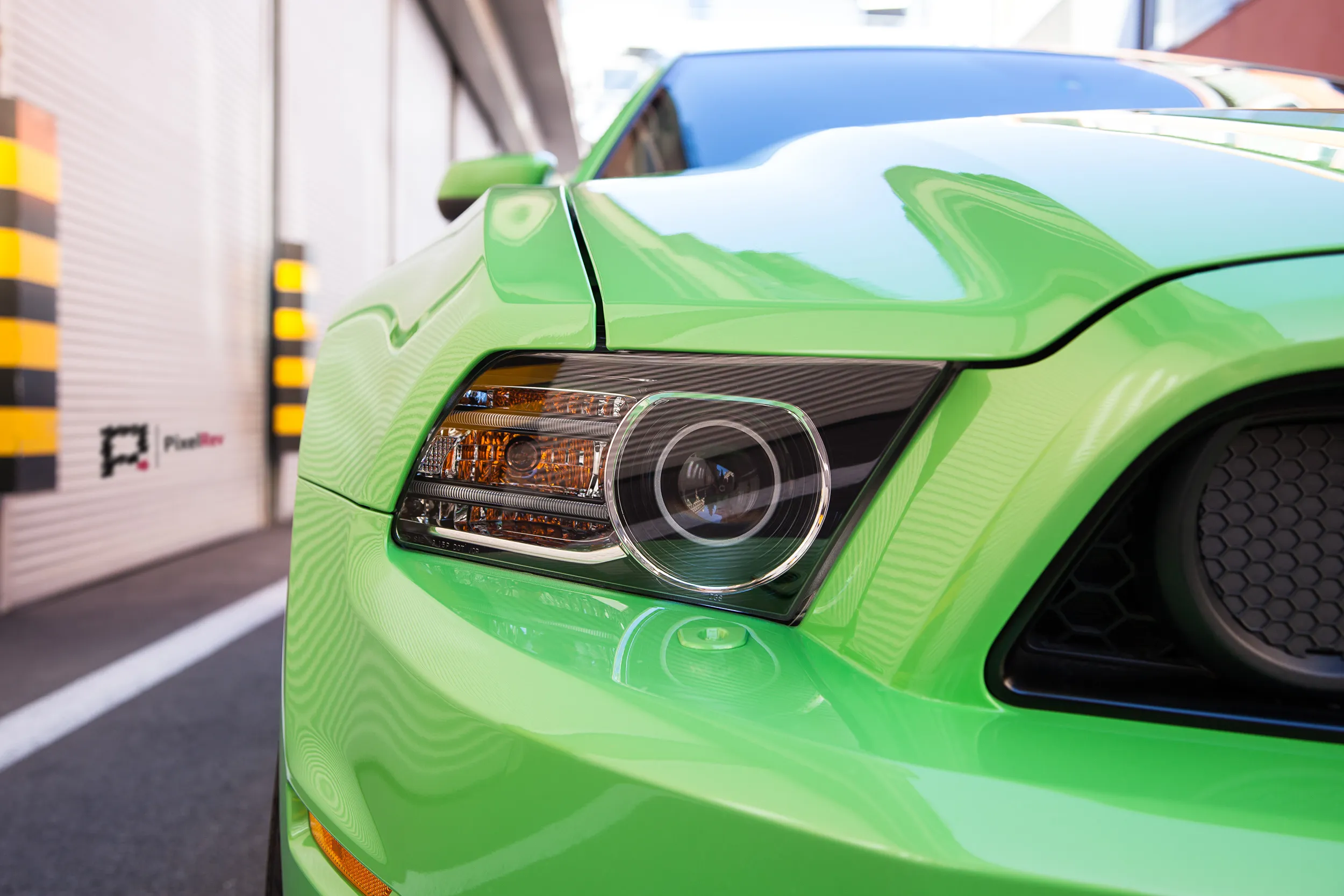 Scheinwerfer eines grünen Ford Mustang Boss 302, Detailaufnahme