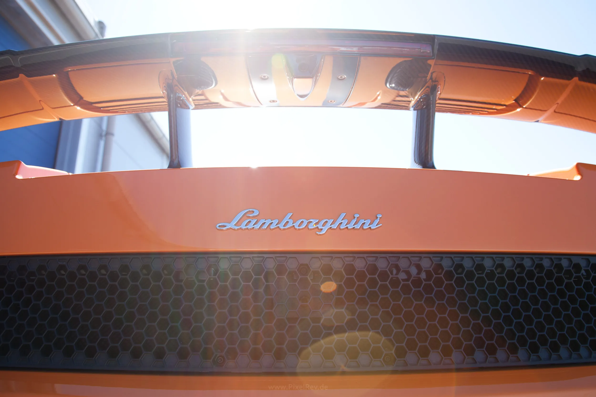 Lamborghini-Schriftzug am Heck eines orangefarbenen Lamborghini, Detailaufnahme