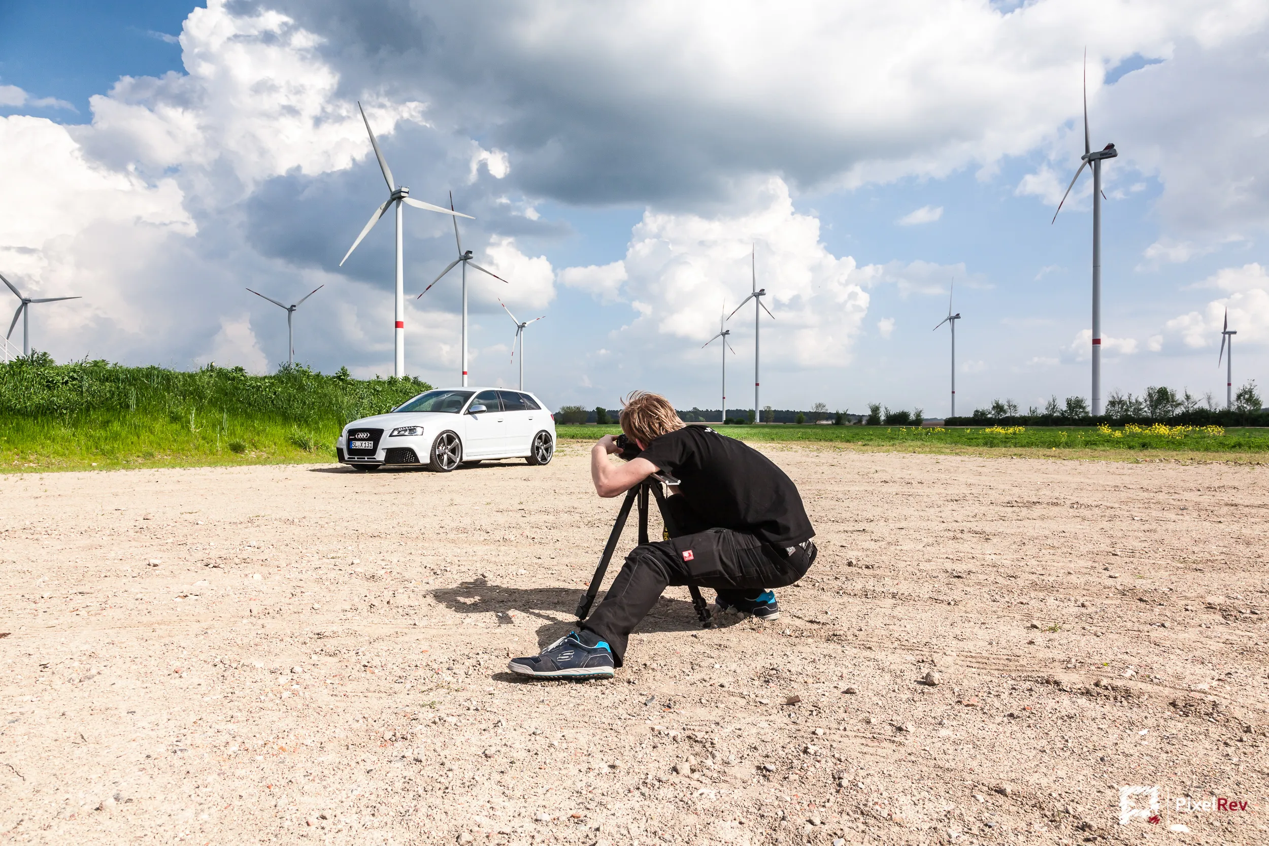 Making-of: Fotograf mit Stativ vor dem Audi RS3 Sportback im Windpark