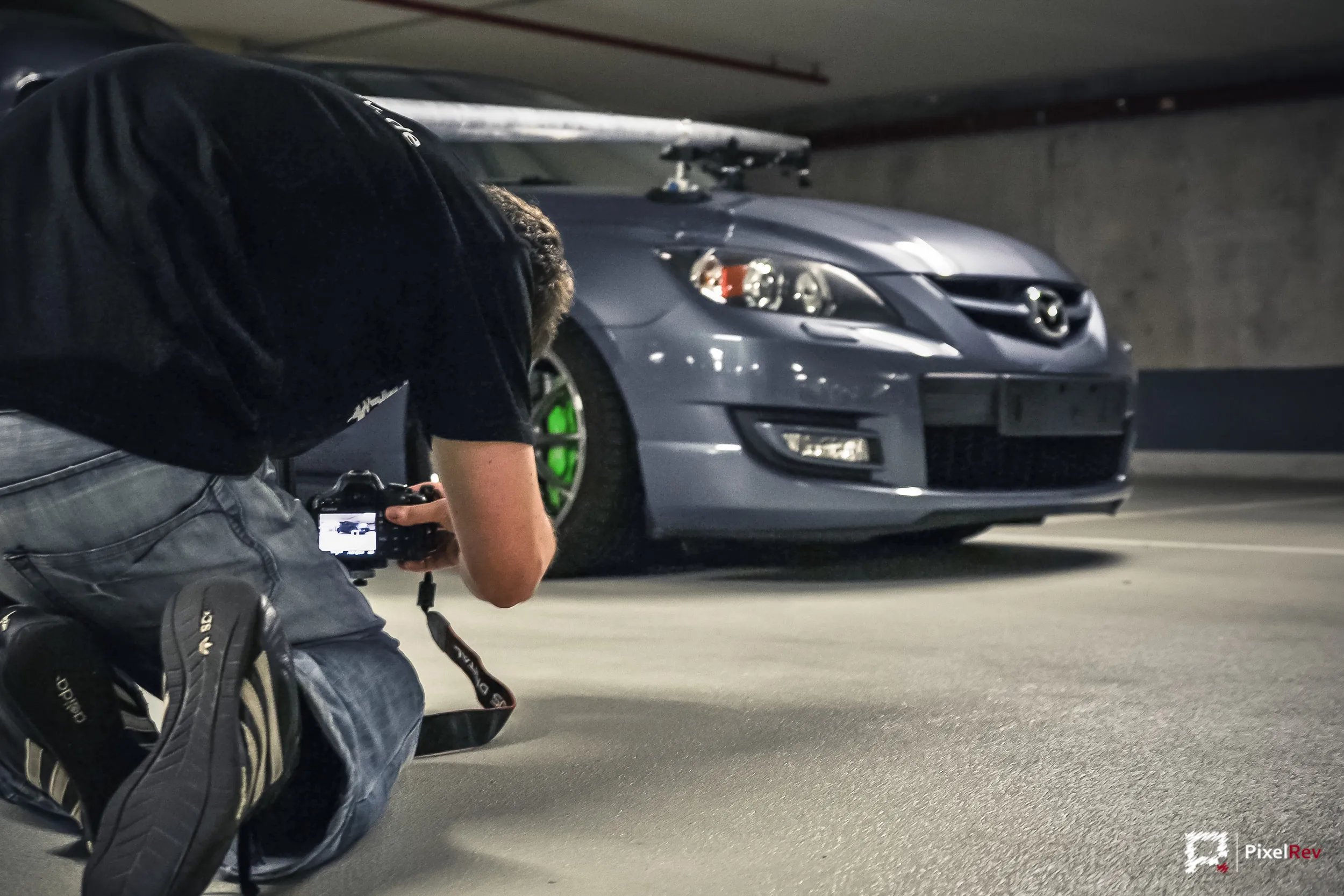 Making-of: Fotograf kniet vor dem grauen Mazda 3 MPS