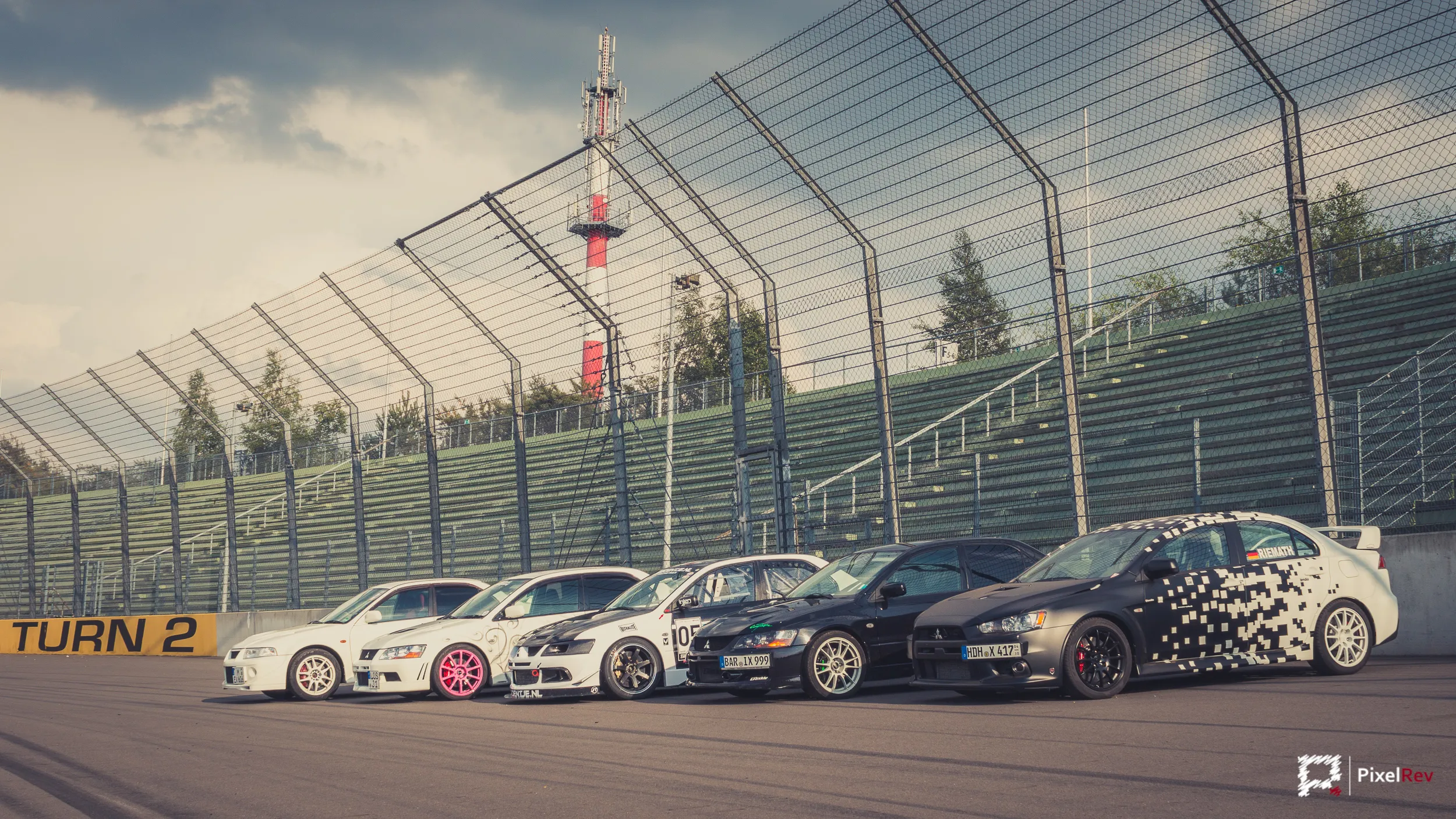Mitsubishi Lancer Evolution in einer Reihe an Turn 2 des Lausitzrings