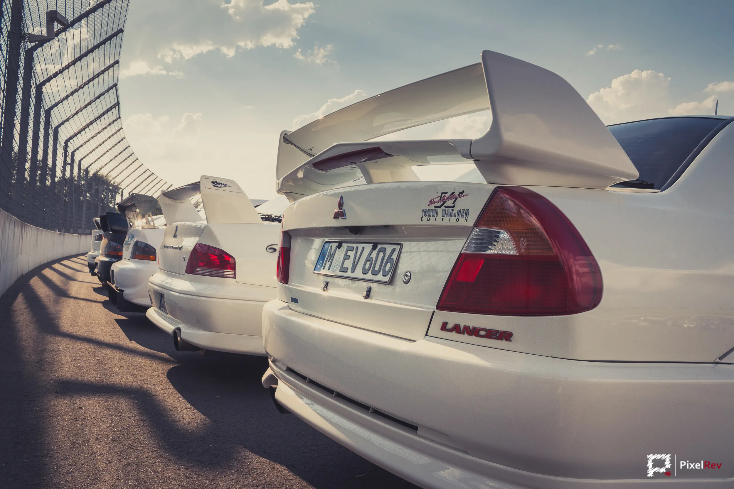 Reihe weißer Mitsubishi Lancer Evolution VI vor der Tribüne am Lausitzring