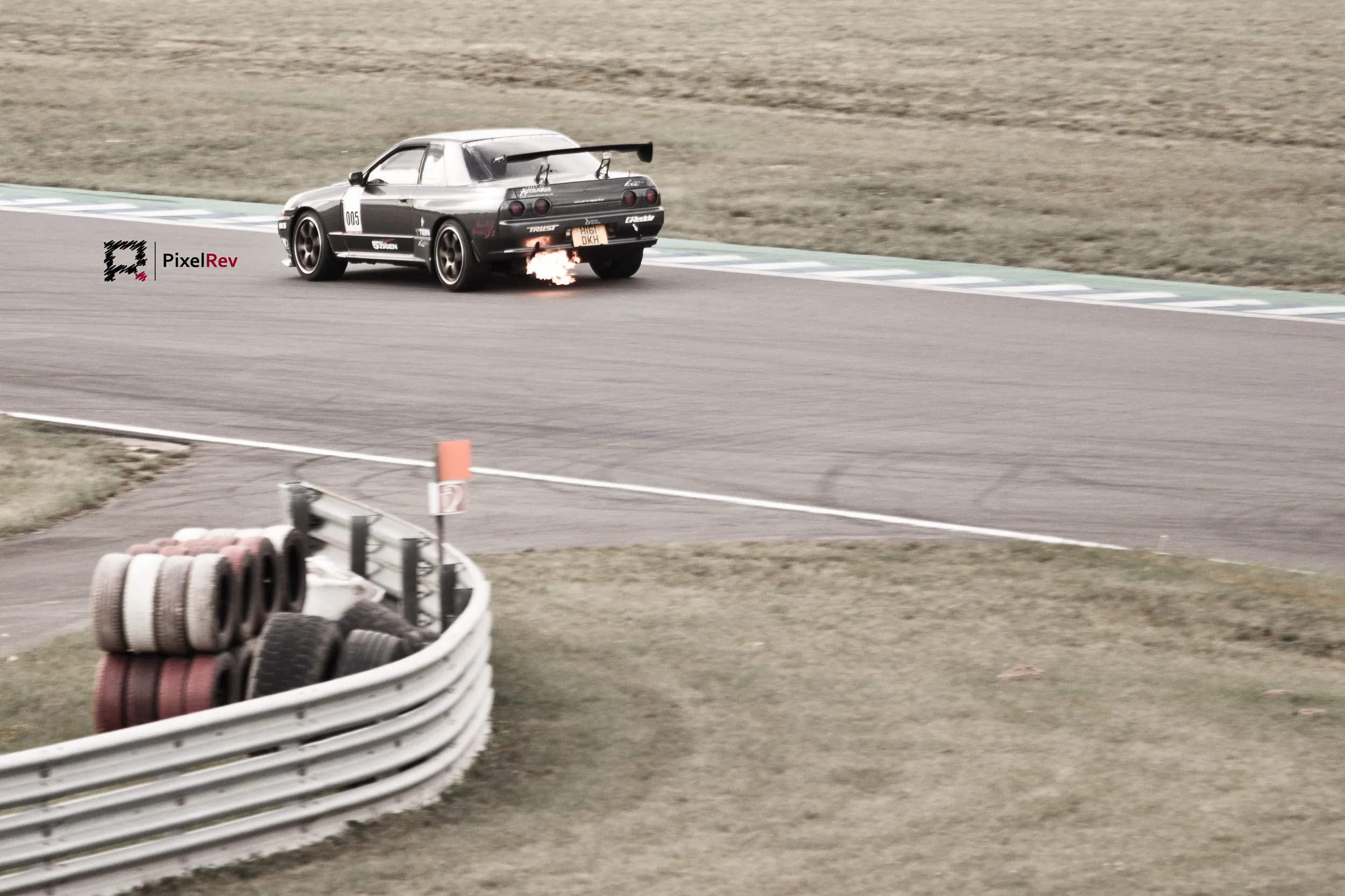 Nissan Skyline R32 mit Flammen aus dem Auspuff auf der Rennstrecke in Oschersleben