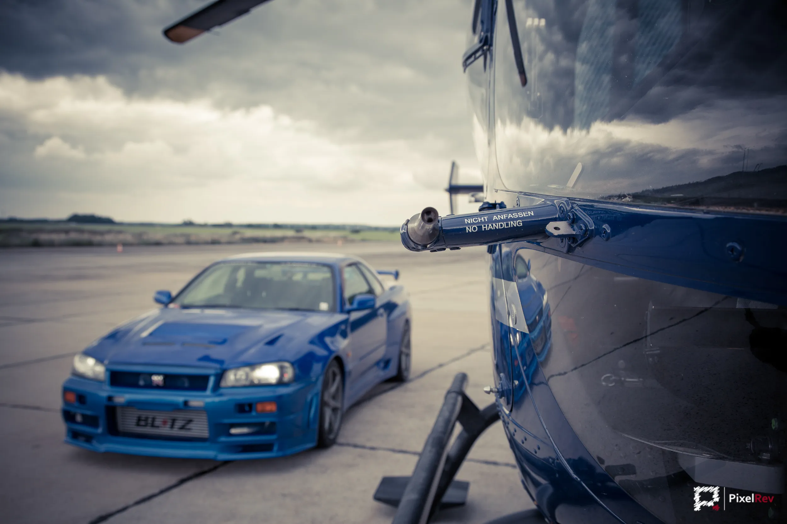 Nissan Skyline R34 GT-R, am Rumpf eines Hubschraubers vorbei fotografiert
