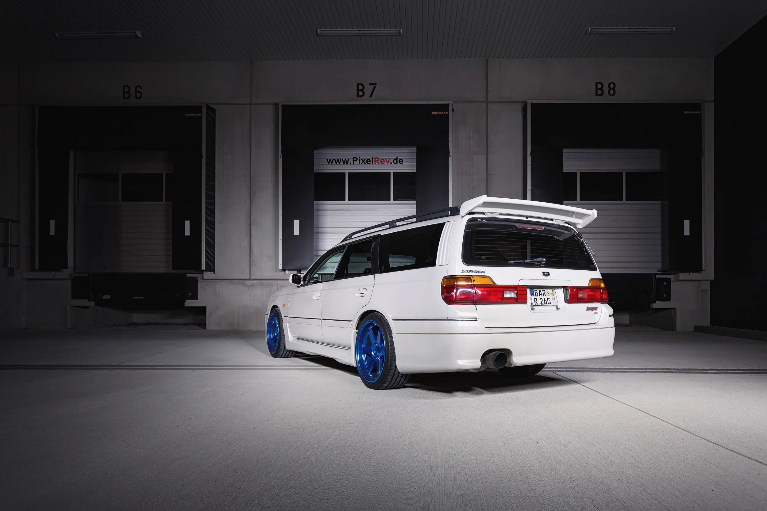 Heck des Nissan Stagea vor Ladetoren bei Nacht