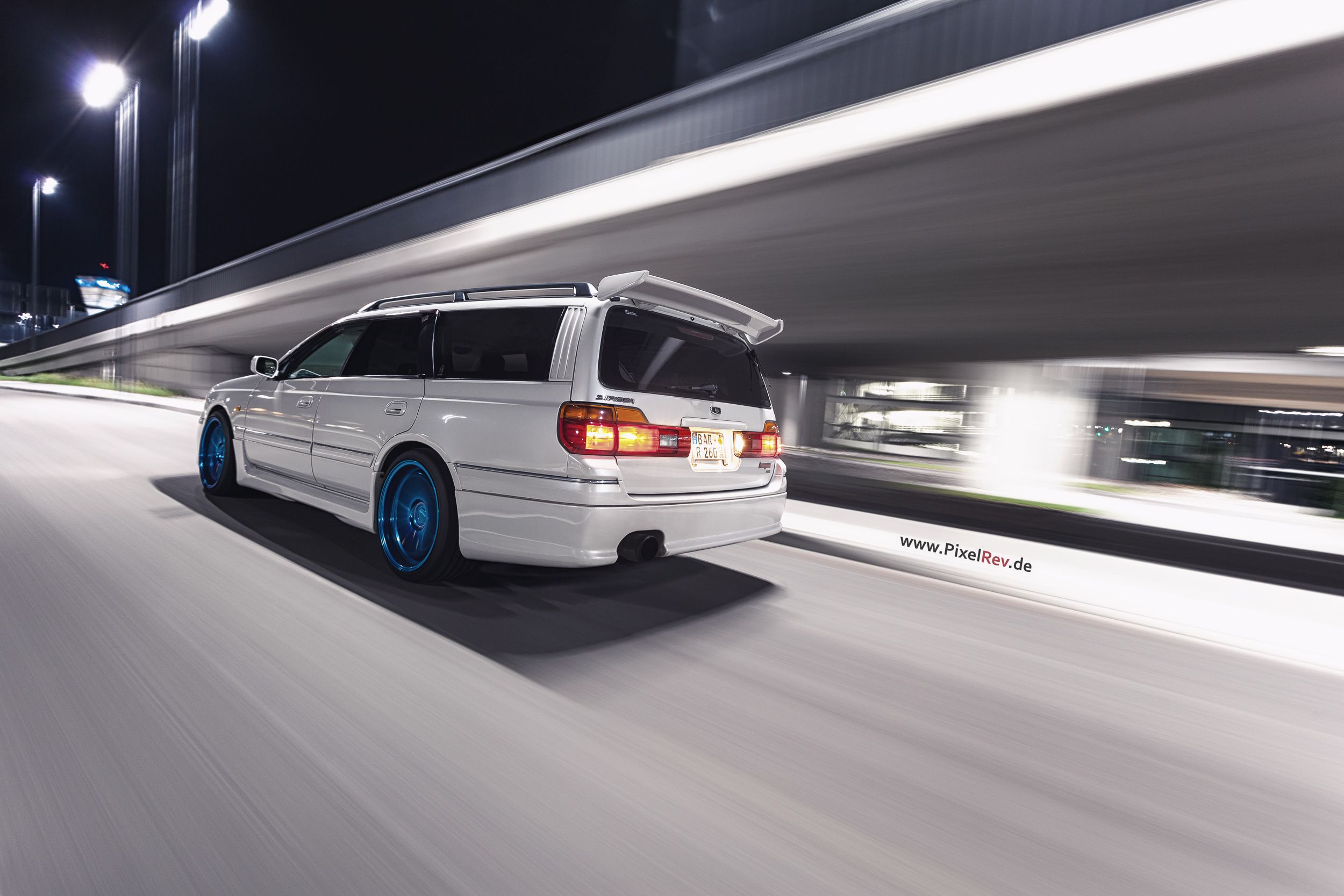 Heck des weißen Nissan Stagea im nächtlichen Rig Shot am Flughafen BER