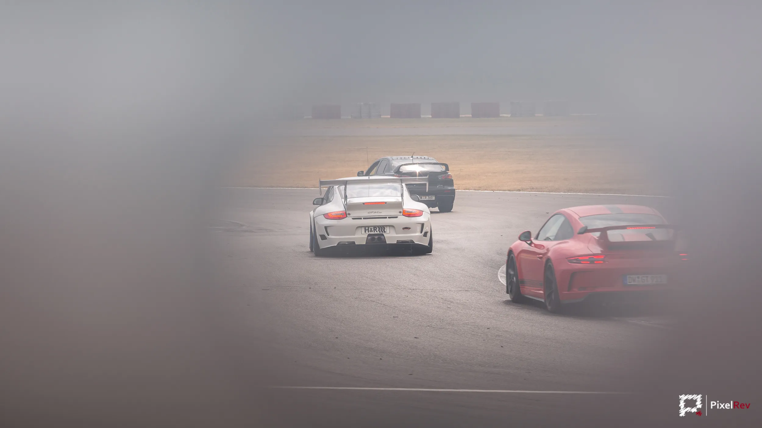 Porsche 911 auf der Strecke, durch einen Zaun fotografiert