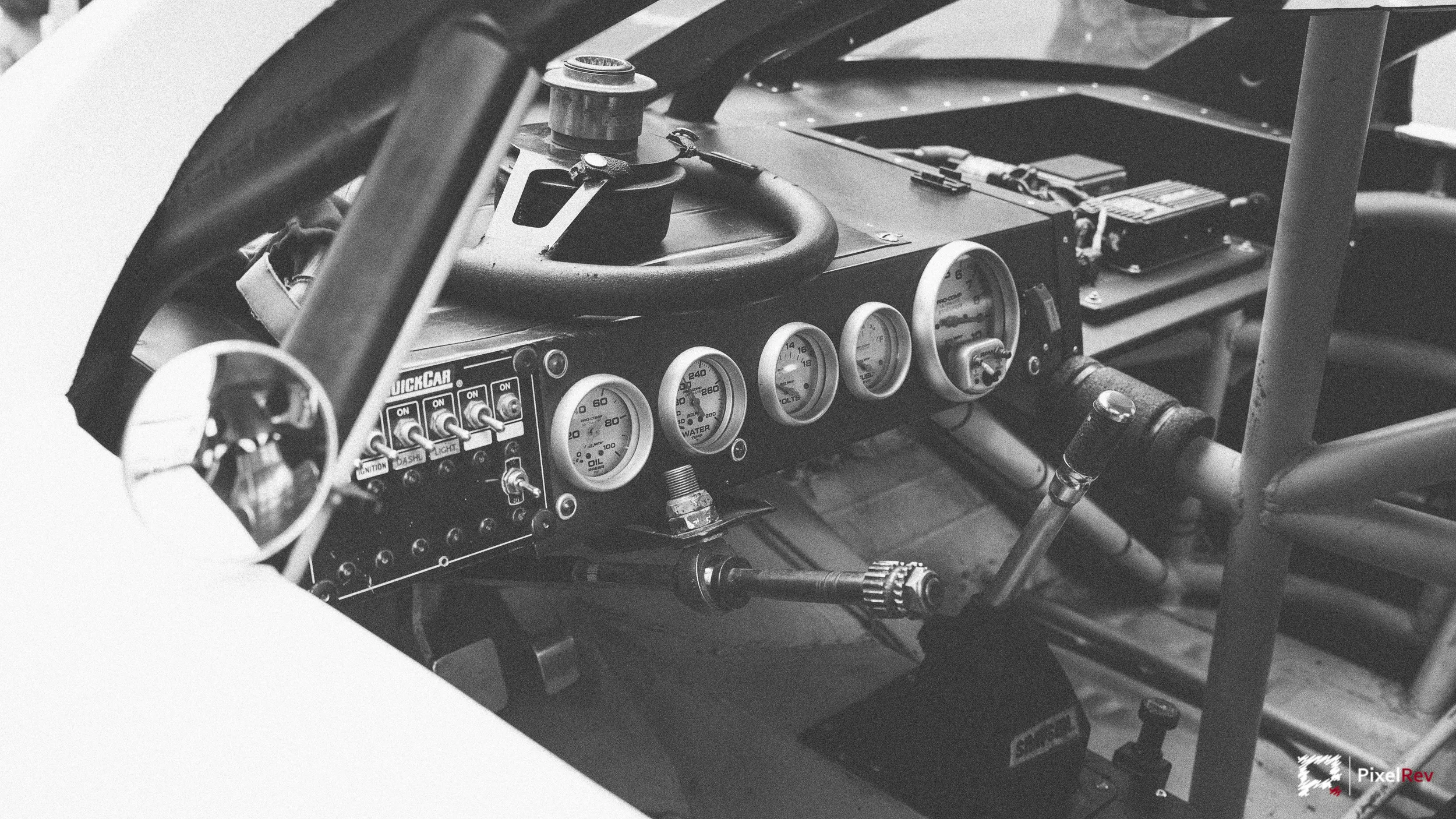 Cockpit eines Rennwagens mit Überrollkäfig und Instrumenten, Schwarz-Weiß