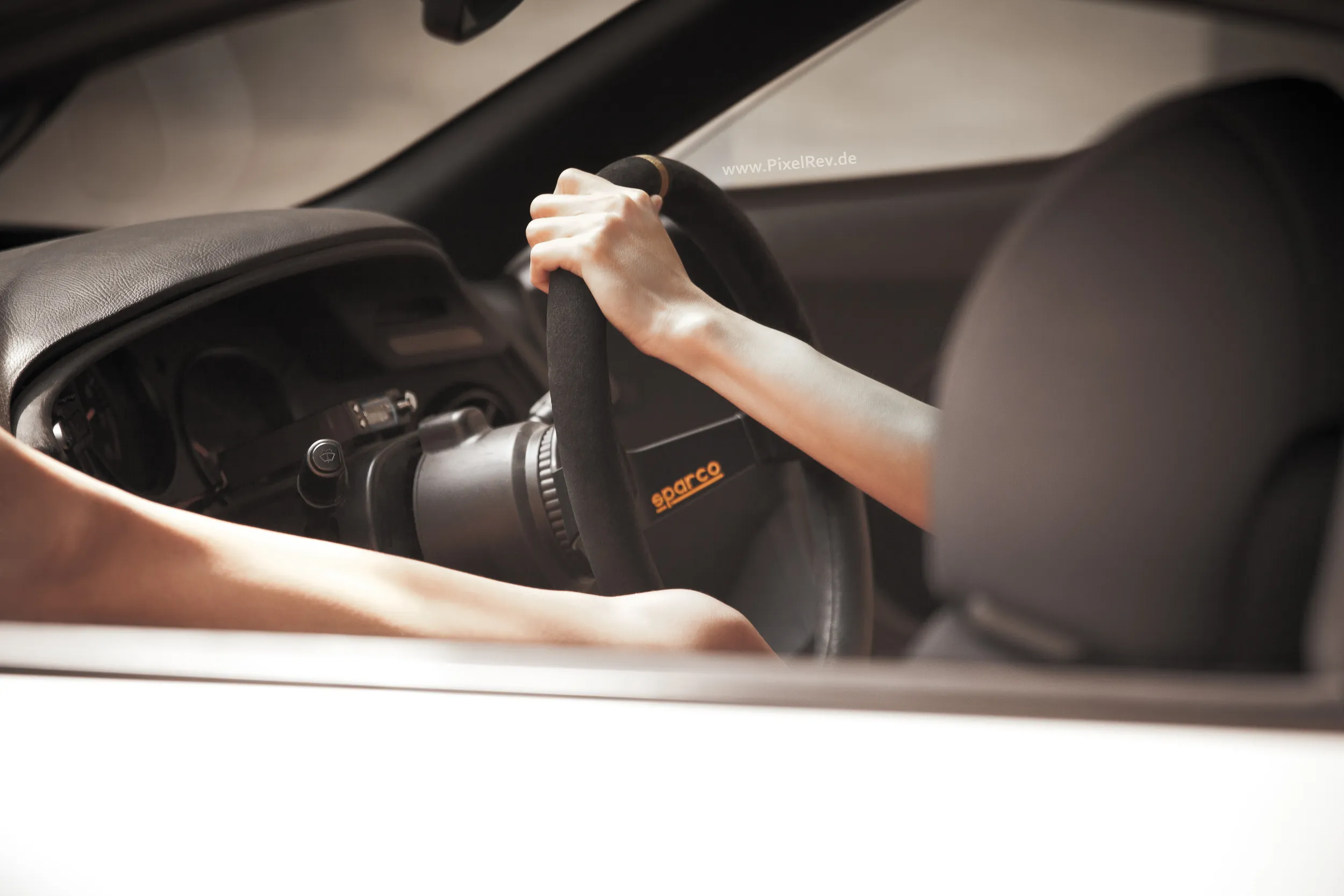 Hand am Sparco-Lenkrad im Innenraum eines Toyota Supra