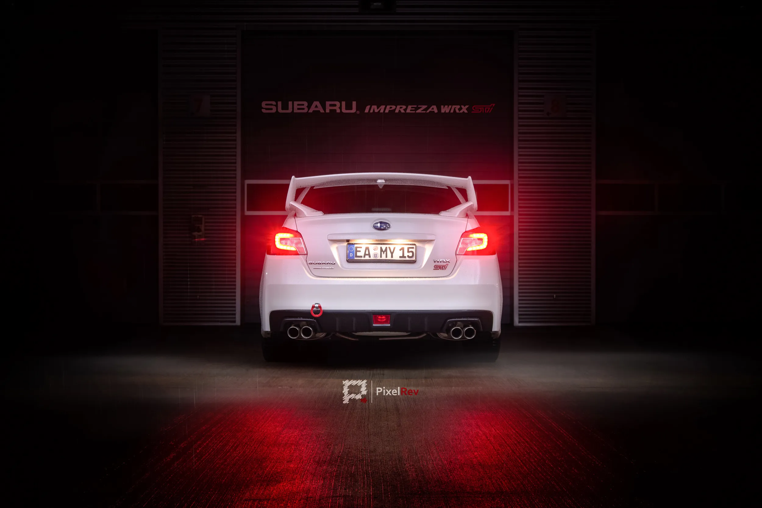 Heck eines weißen Subaru WRX STI vor einer dunklen Box mit Impreza-Schriftzug bei Nacht