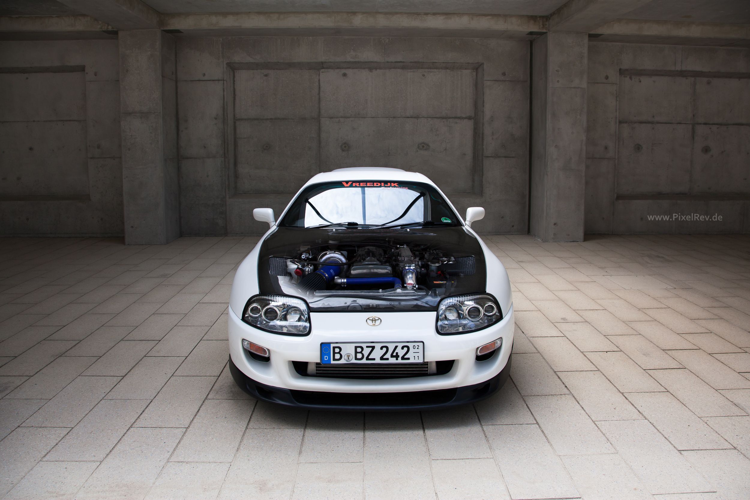 Weißer Toyota Supra frontal mit Blick in den Motorraum