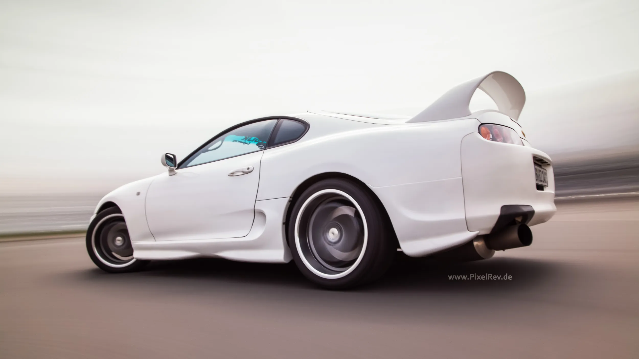 Weißer Toyota Supra im Rig Shot, Umgebung in Bewegungsunschärfe